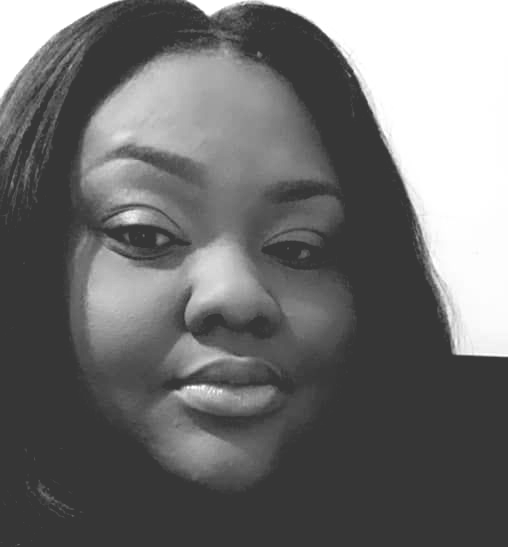 Woman with dark hair, looking at the camera, with a slight smile.