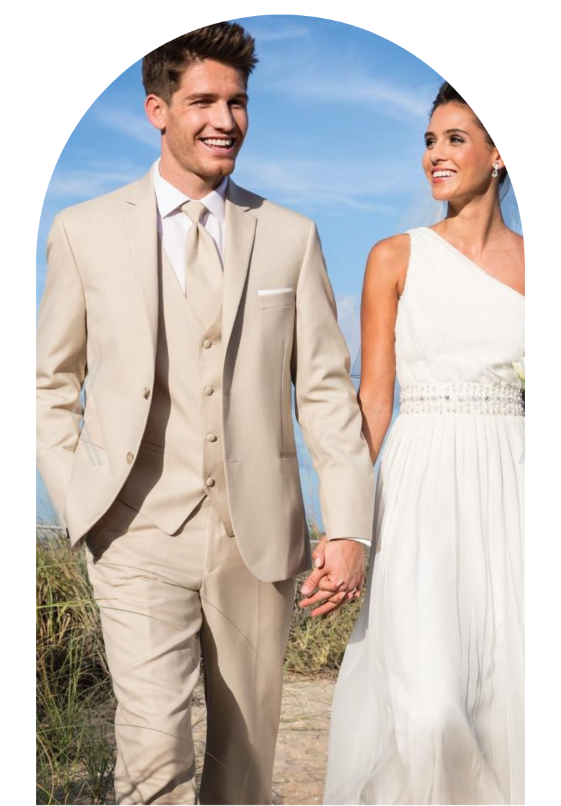 Couple in cream wedding attire walking outdoors against a blue sky