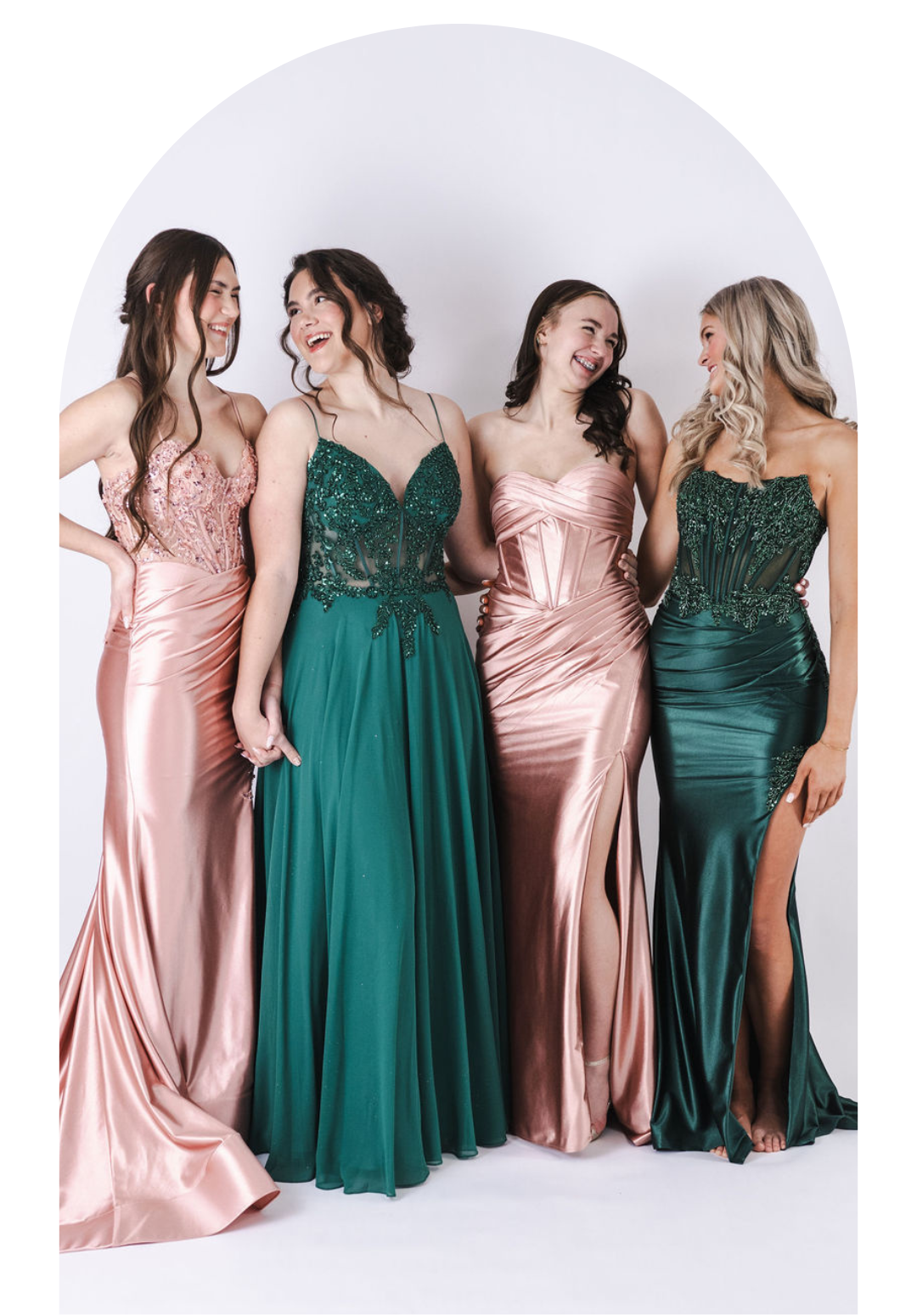 Four women in floor-length formal dresses posing against a white studio backdrop