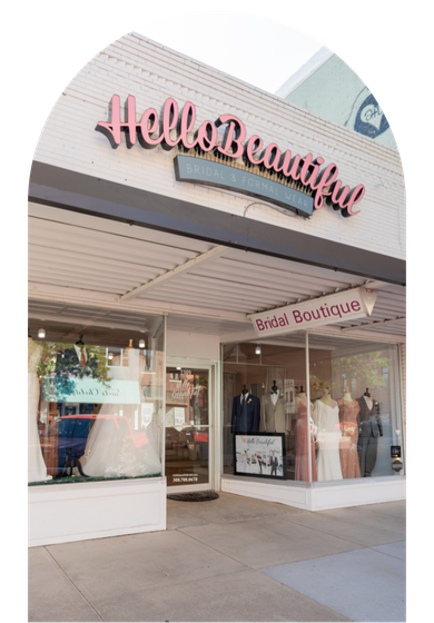 Exterior of Hello Beautiful boutique with pink sign and bridal dresses in the storefront window