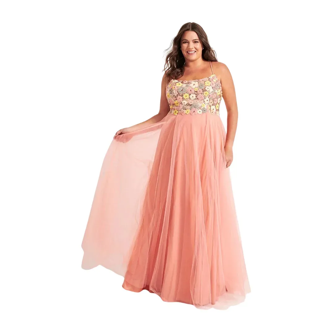 Woman in a peach gown with floral bodice, holding a sheer flowing skirt panel against a white background