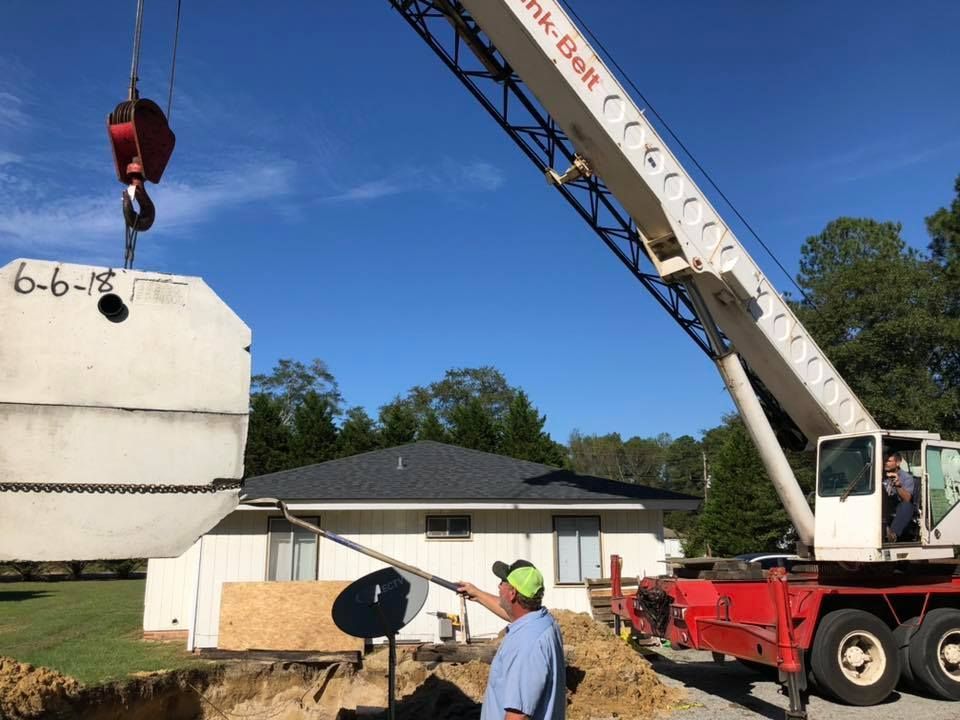 A man is standing in front of a crane that has the number 6 on it