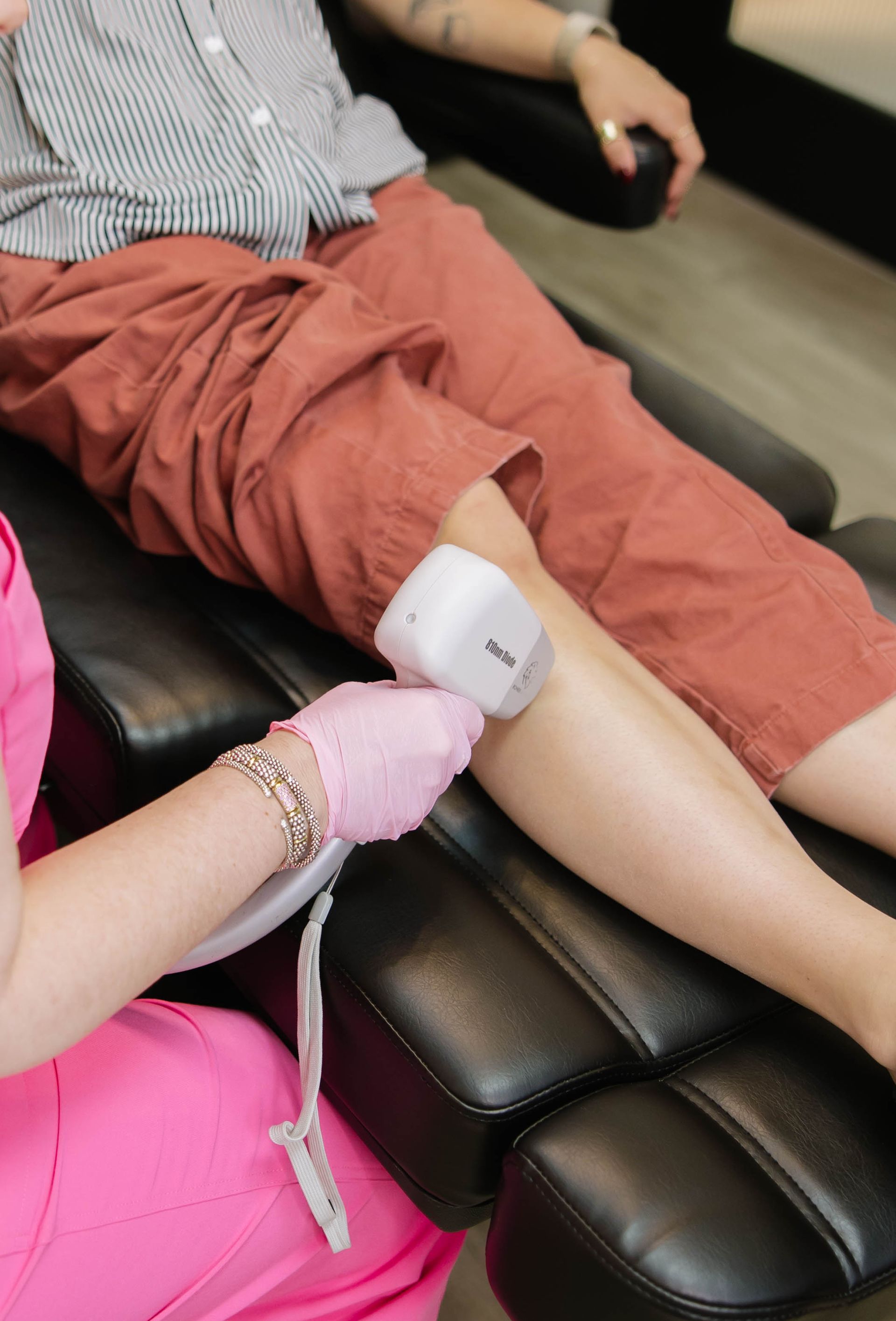 Person receiving laser hair treatment on their leg.
