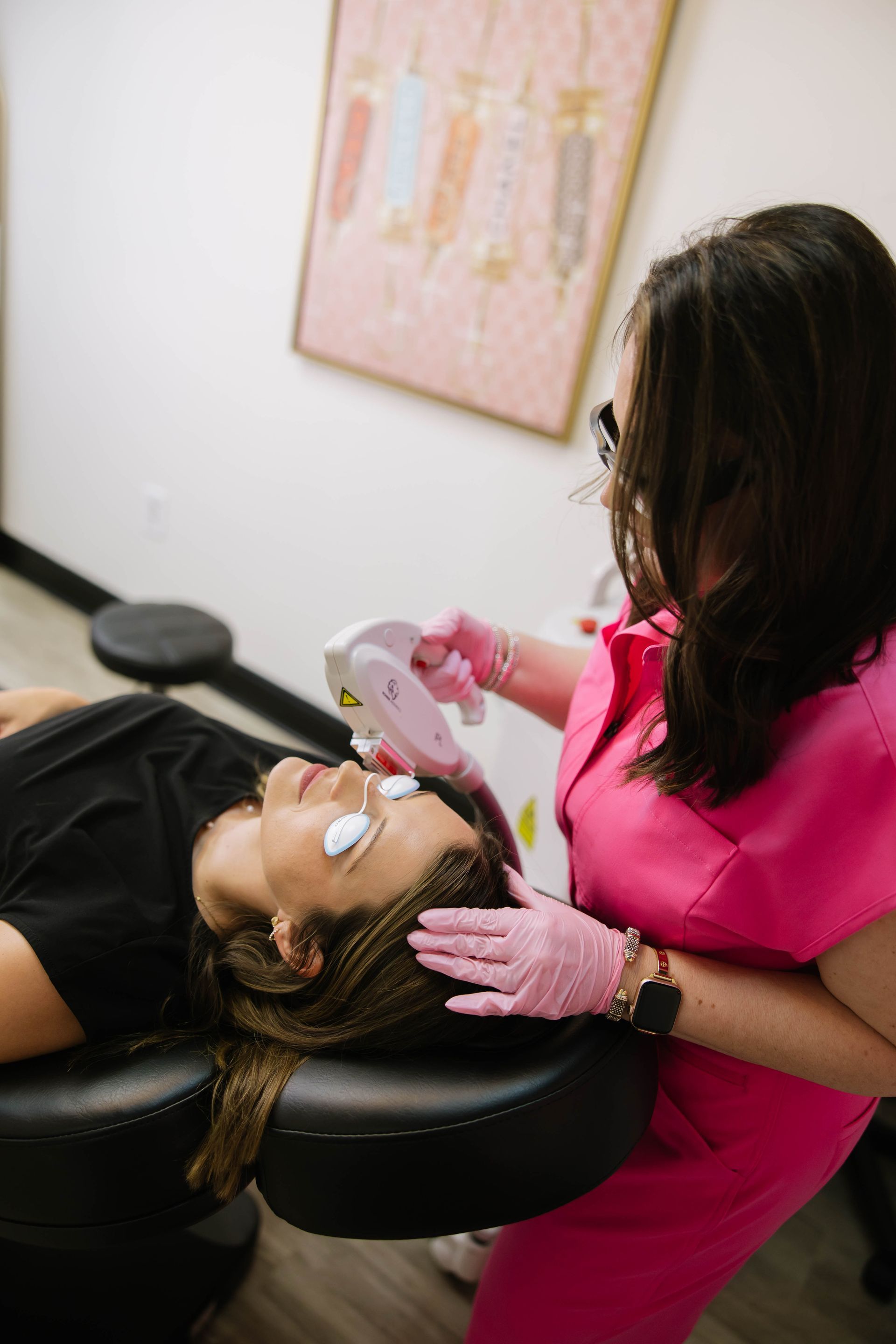 Kimberly Hines, APRN, examining a client reclining in a chair, using pink gloves and a mirror in a clinic.