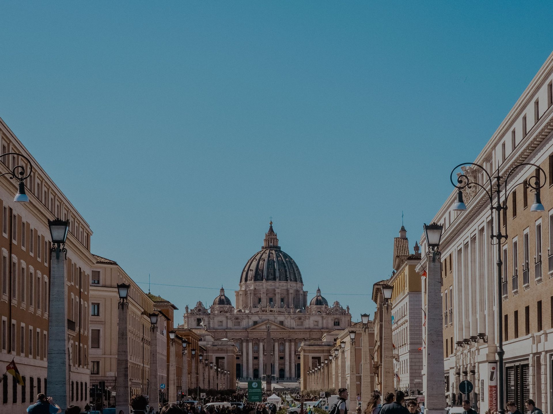 Wide street leading to St. Peter’s Basilica in Rome under a clear blue sky
