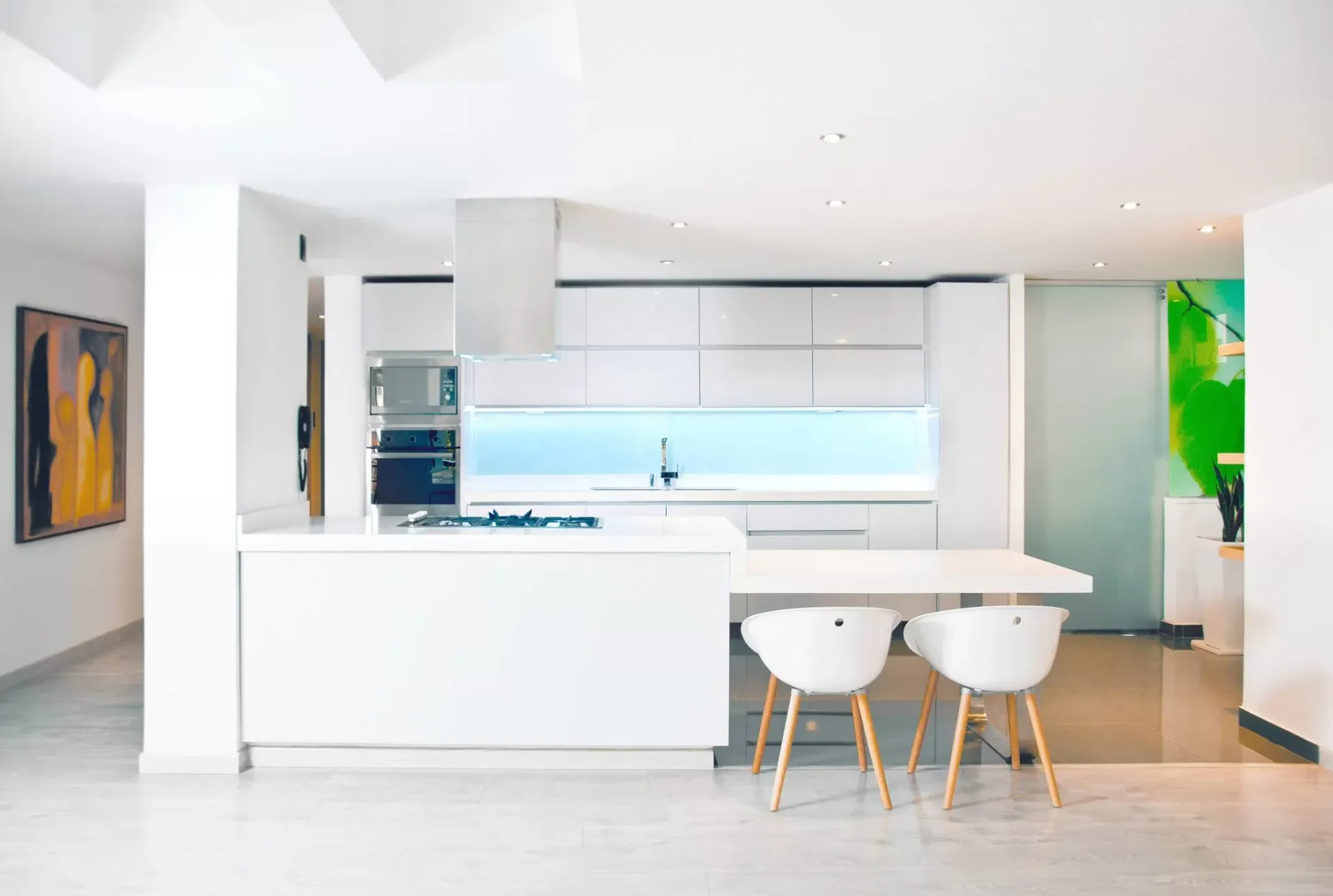 A kitchen with white cabinets and white chairs