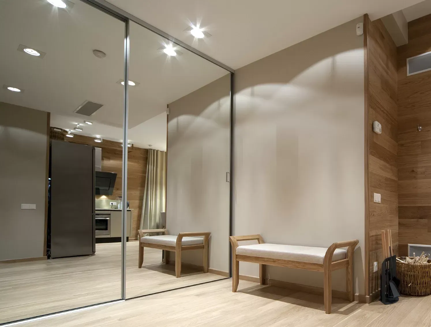 A hallway with a bench and a large mirror
