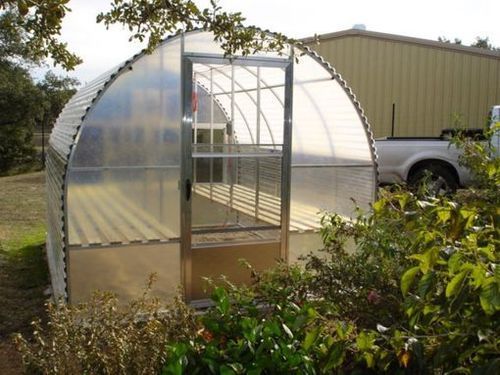 A greenhouse with a truck parked in front of it