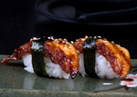 Two glazed eel nigiri sushi pieces with seaweed strips on a dark plate