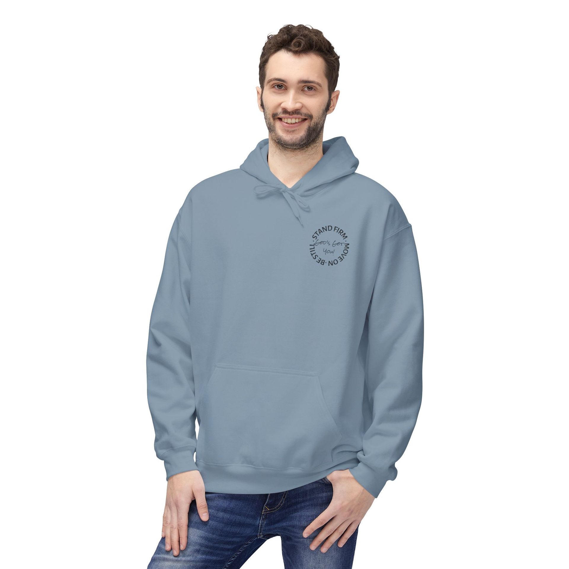 Man wearing blue hoodie with small logo on chest. He smiles, stands indoors.