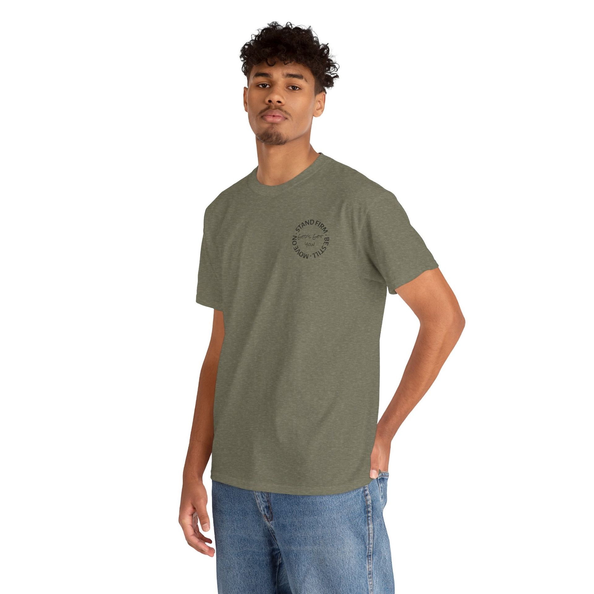 Man wearing a green t-shirt and jeans, standing with his hand in his pocket.
