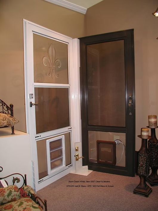 Two screen doors, one white and one dark, open, revealing a pet door.