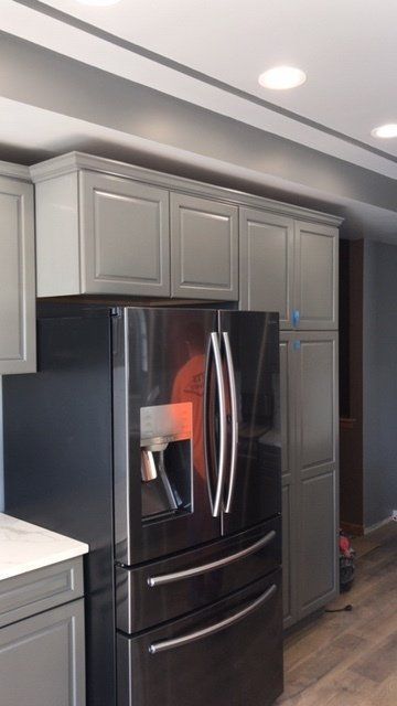 Modern kitchen with gray cabinets and a black French-door refrigerator with water dispenser