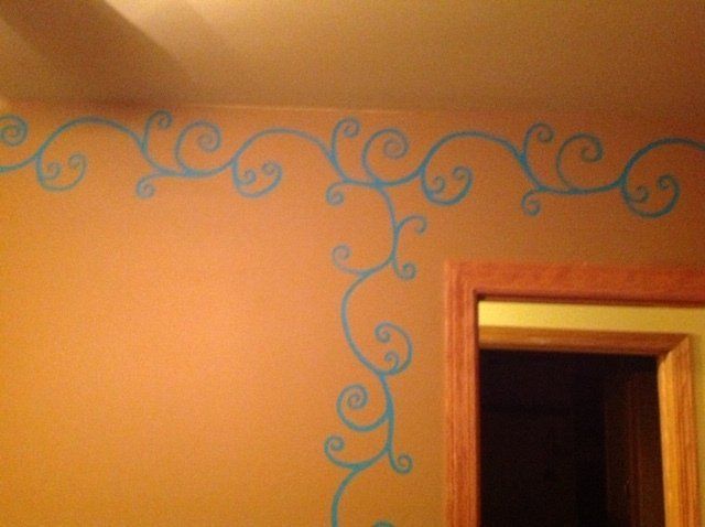 Blue swirl wall border around an orange wall and doorway