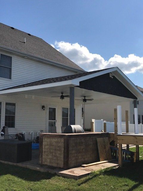 Backyard deck with a covered patio, grill, and above-ground pool beside a house