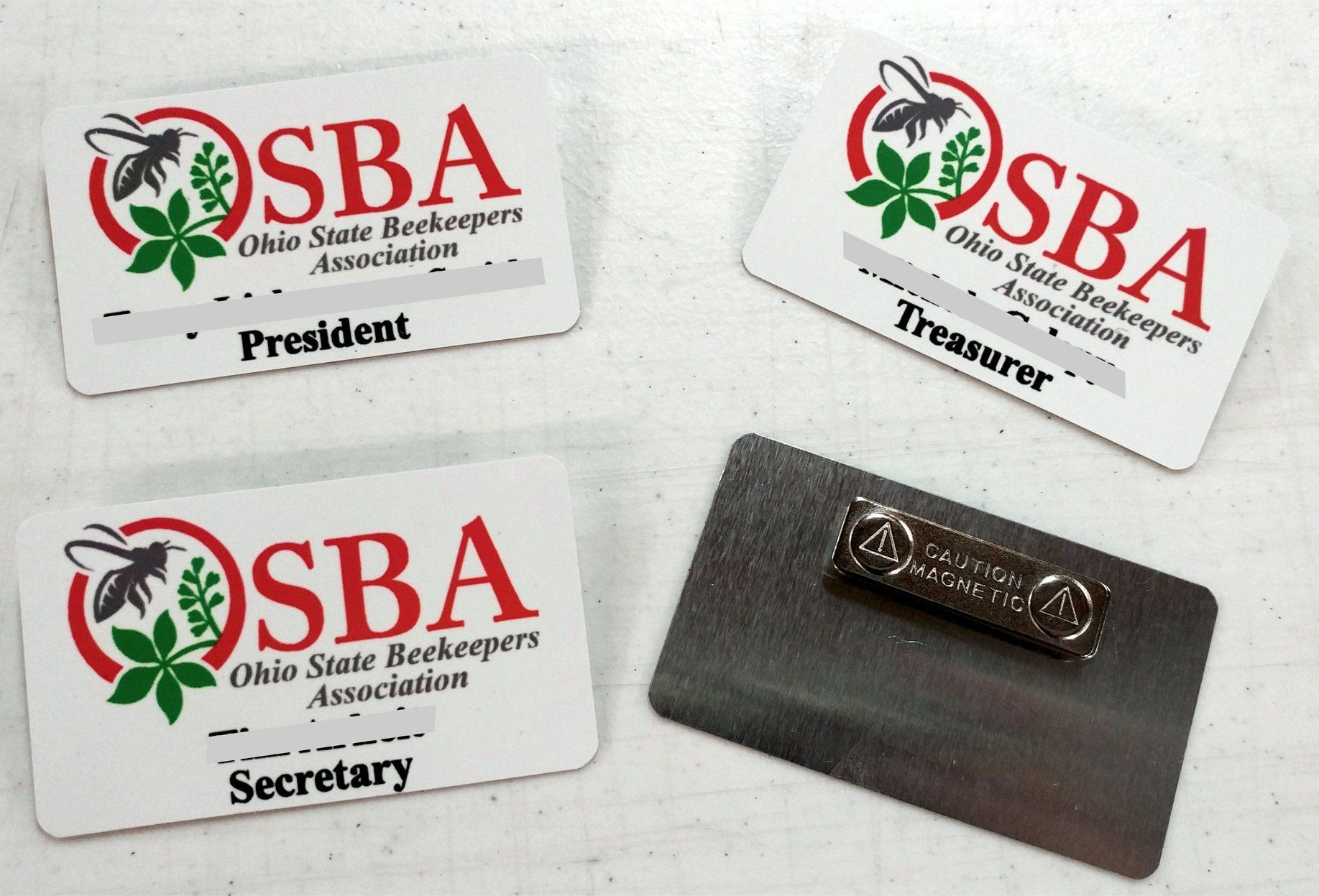 Three Ohio State Beekeepers Association name tags labeled President, Treasurer, and Secretary, plus a magnetic backing.
