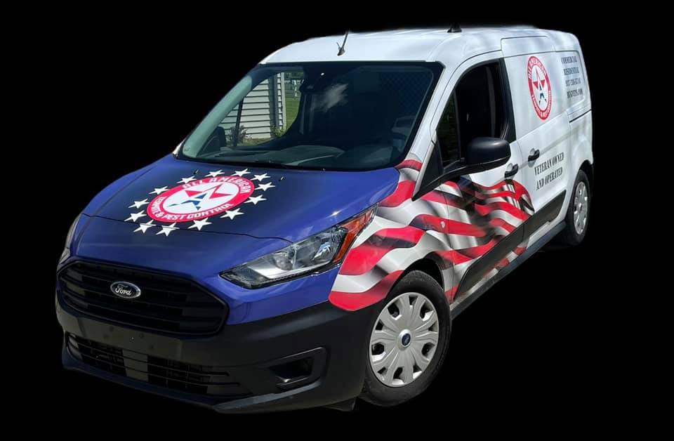 A white Ford Transit Connect van with a blue hood, American flag graphics, and branding logos