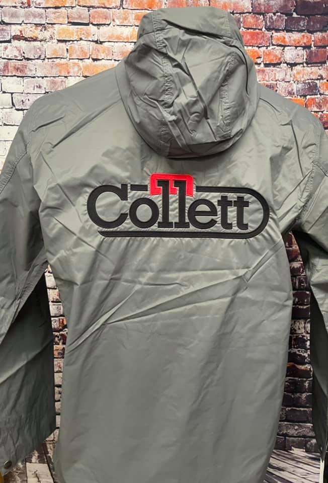 A grey windbreaker jacket with a hood featuring the red and black 