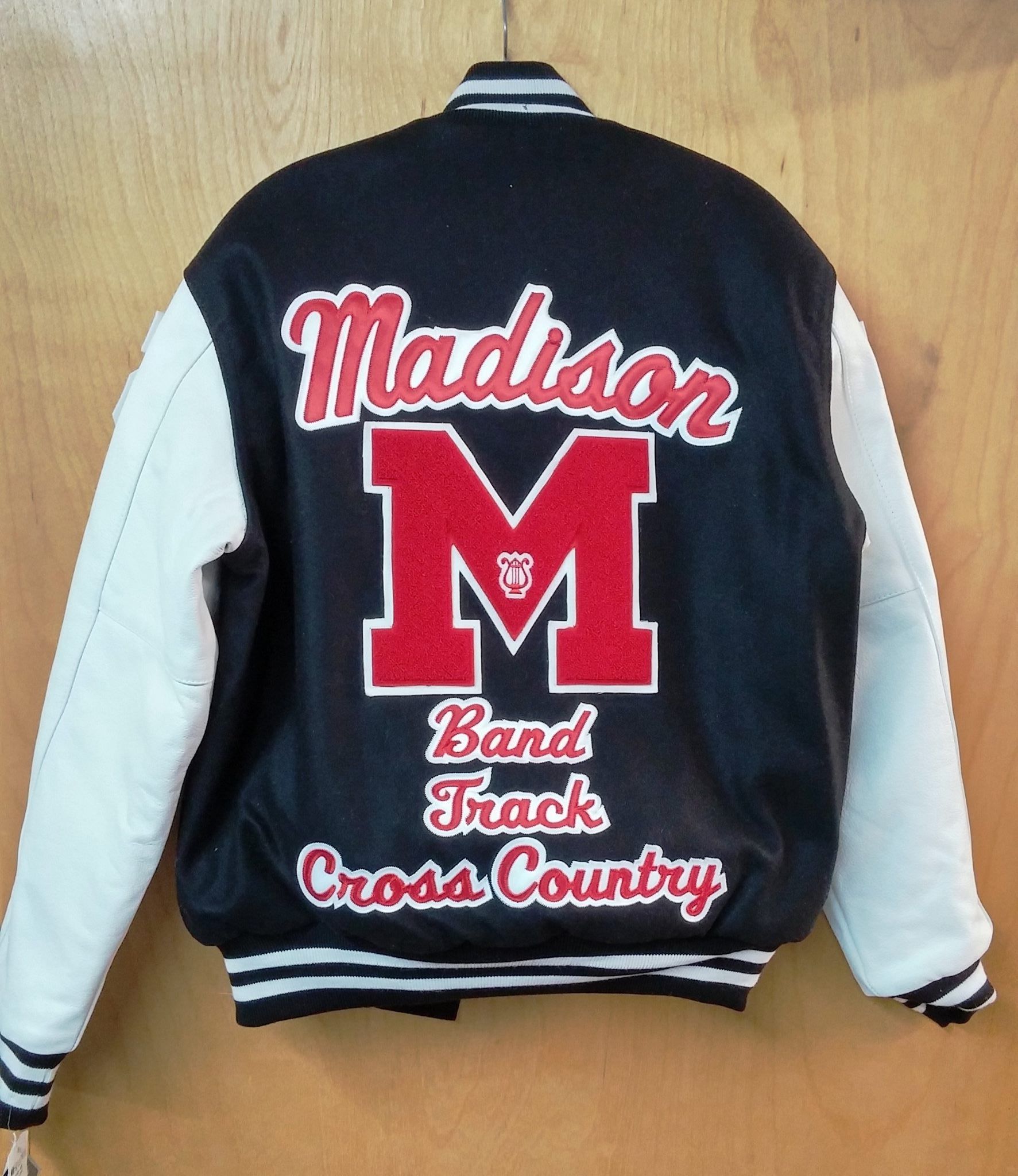 A navy blue and white varsity jacket featuring a red 