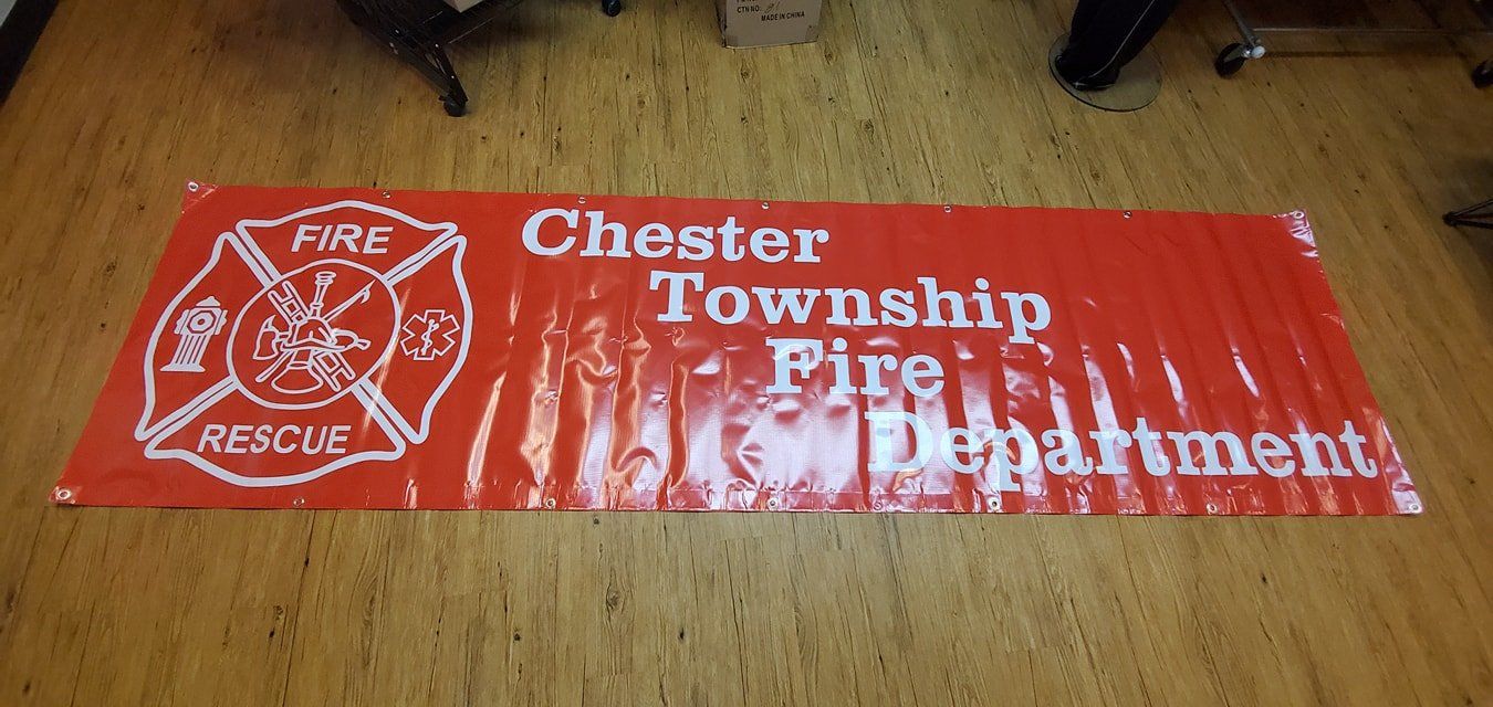 A long red banner on a wood floor featuring the white Chester Township Fire Department logo and text.