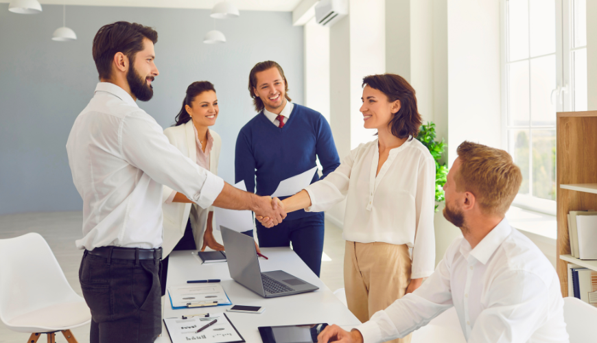 Um grupo de empresários apertam as mãos em um escritório.