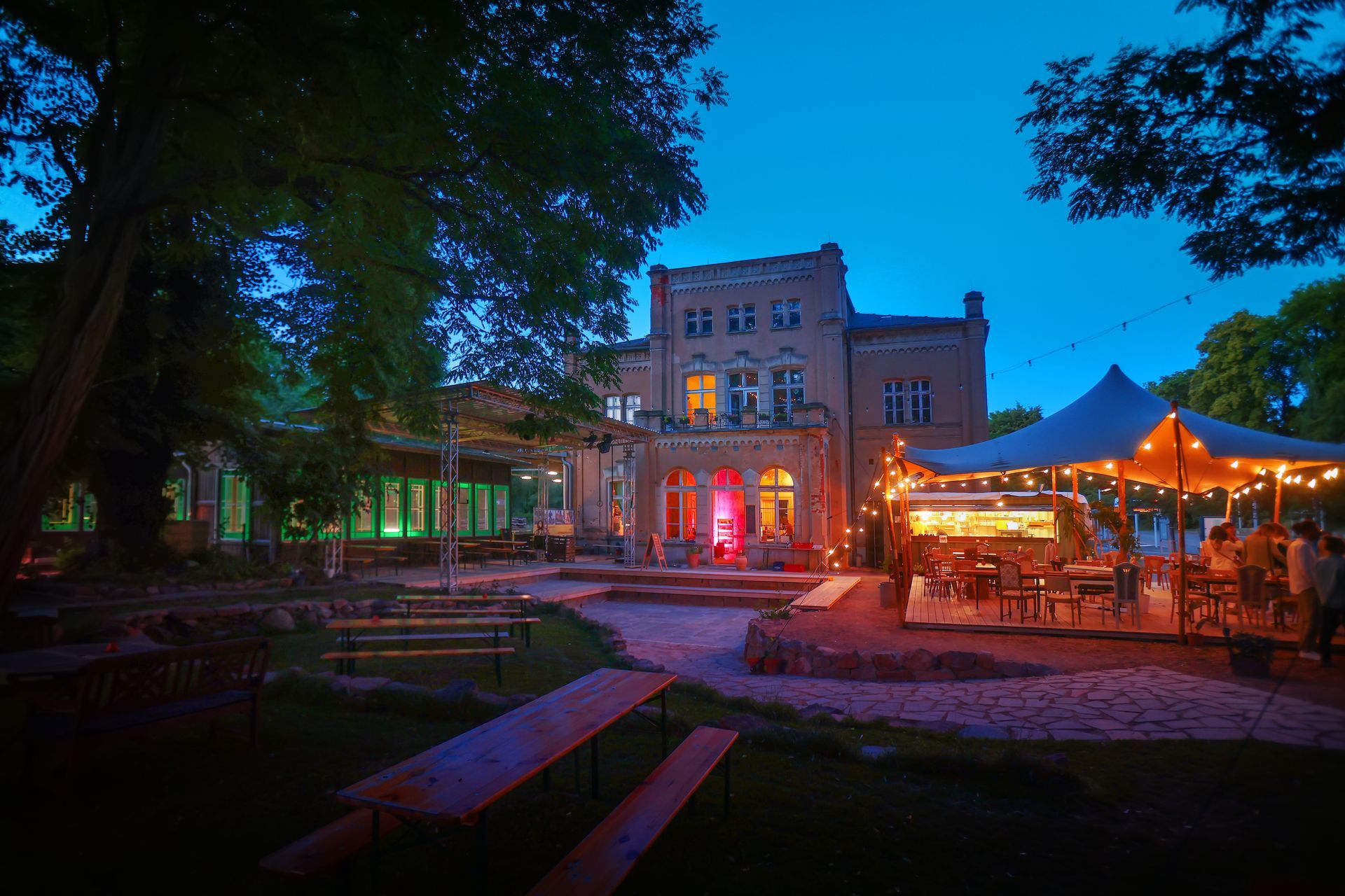 Kulturbahnhof Leisnig am Abend mit bunten Farben beleuchtet und dem Freisitz