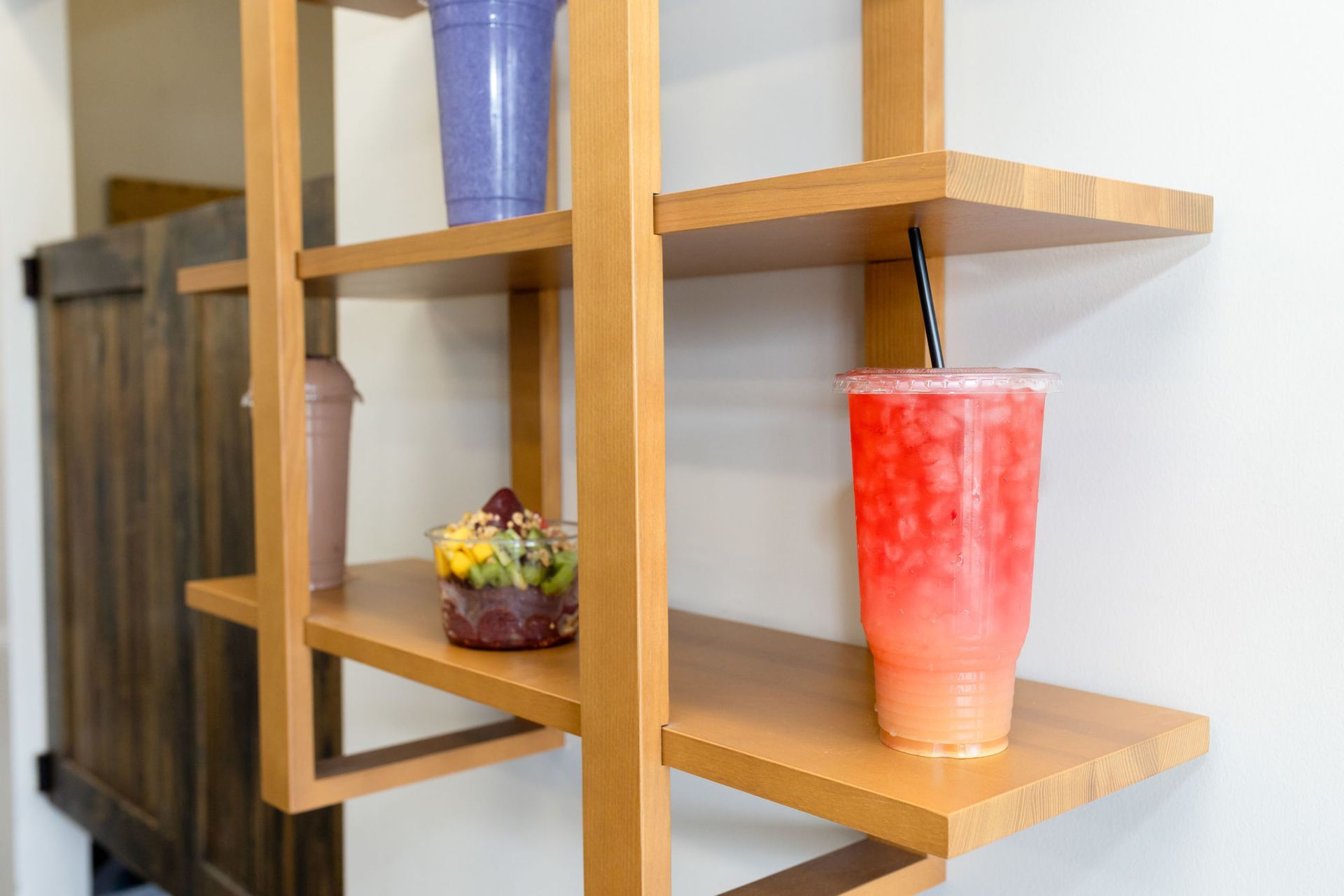 A wooden shelf with a cup of drink on it.