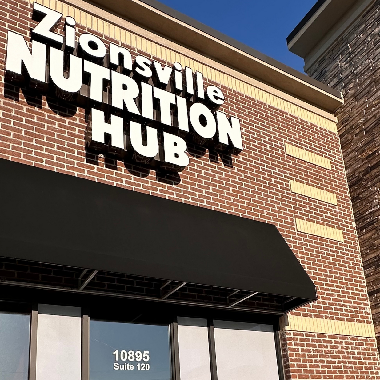 A brick building with a sign that says zionsville nutrition hub