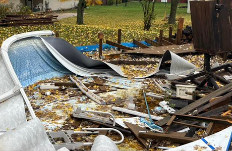 A pile of junk is laying on the ground next to a swimming pool.