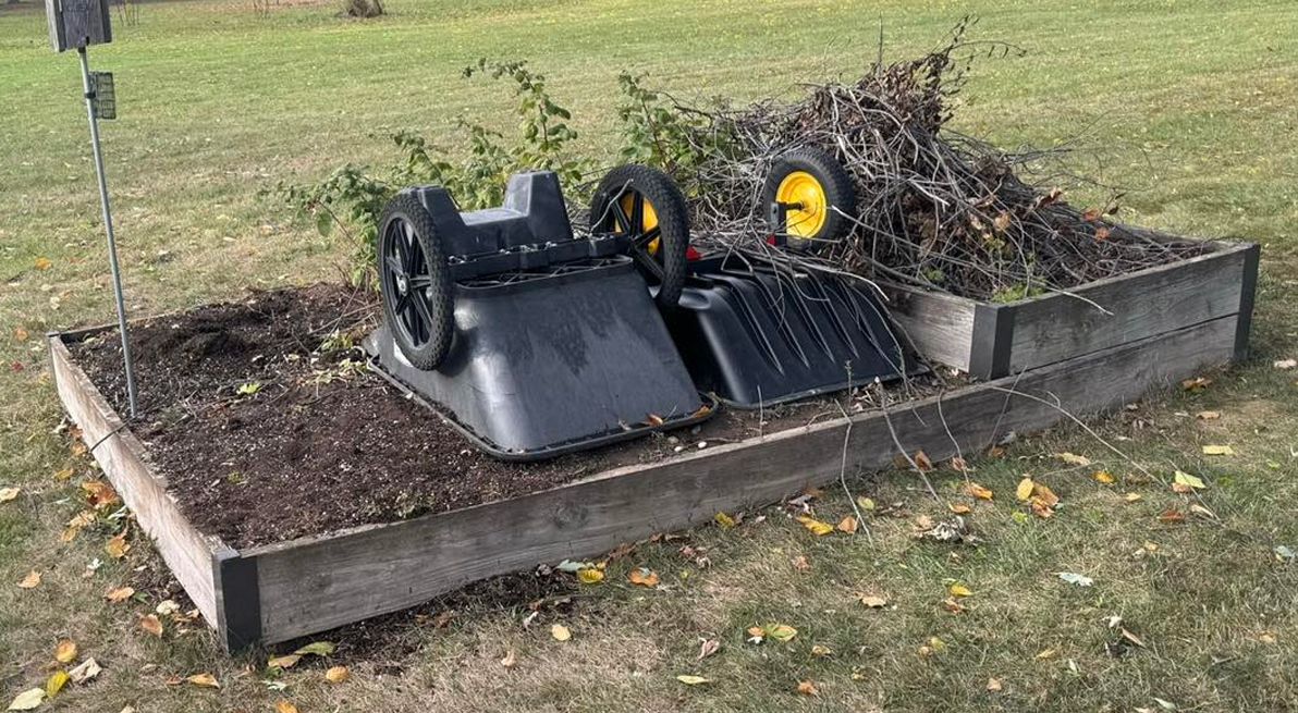 A lawn mower is sitting on top of a wooden box in the grass.