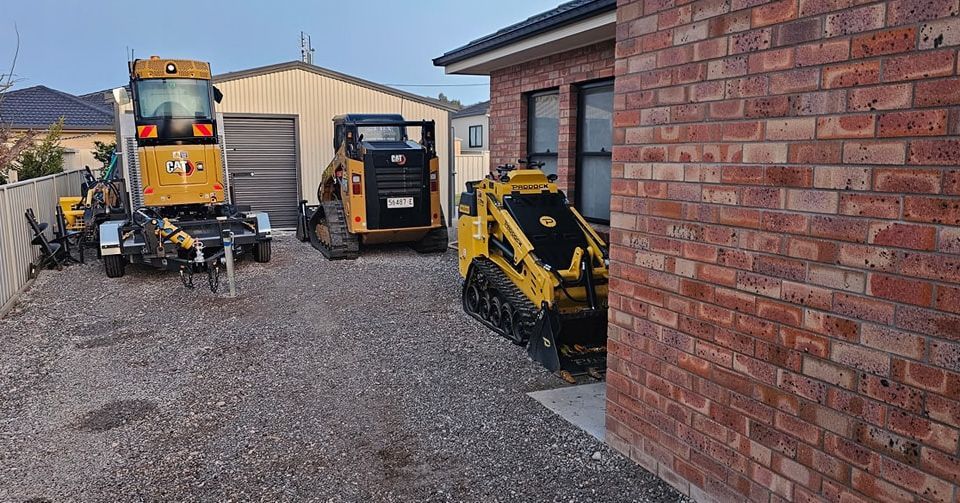 Green and yellow skid steer loader on grass.