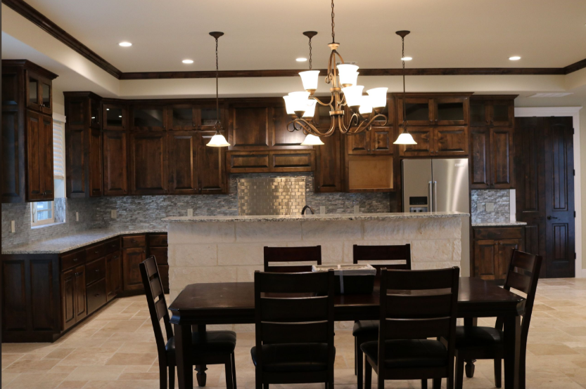 Dark wood kitchen with matching cabinets, granite countertops, and dining table set.