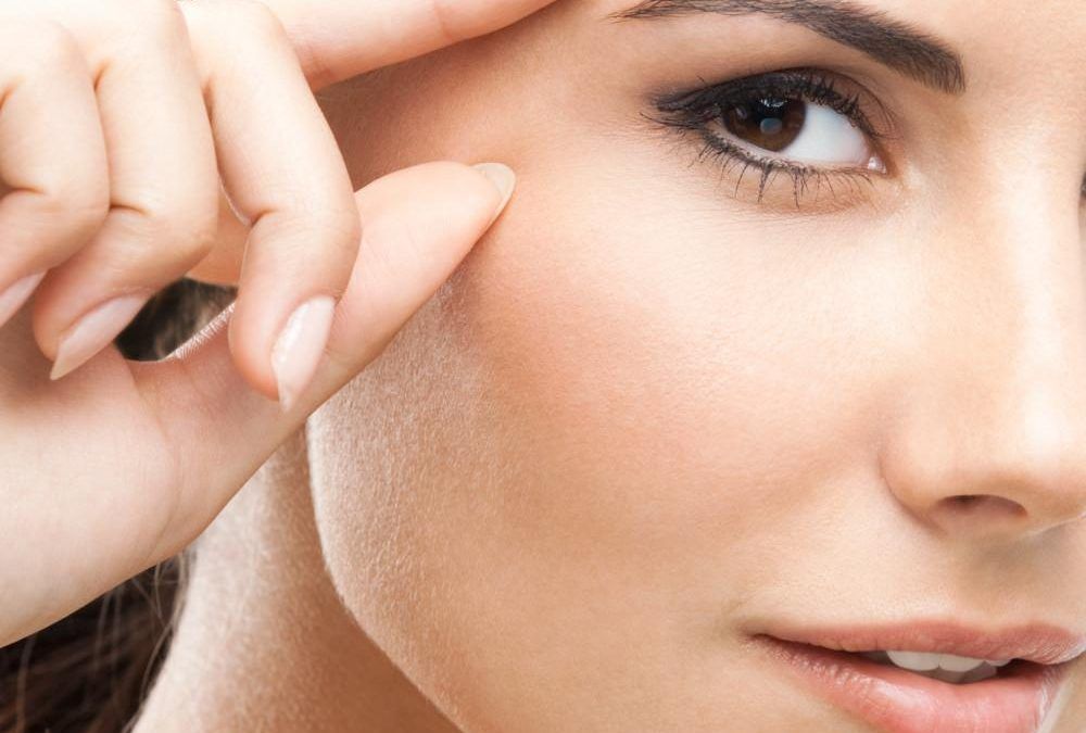 woman pointing to crow's feet area of face