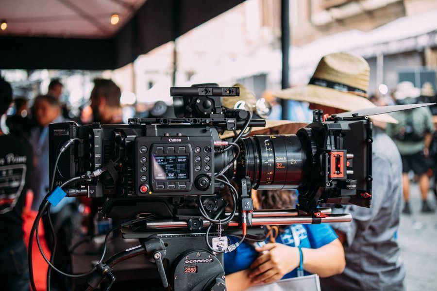 Close-up of a professional video camera being operated at an outdoor event