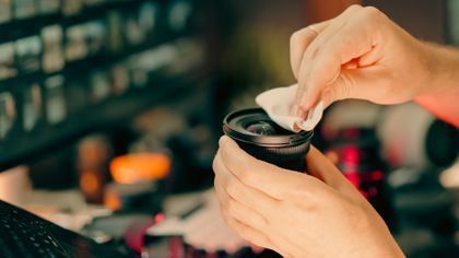 Hands opening a takeout coffee cup with a lid against a blurred café background