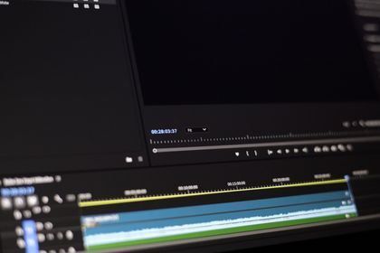 Dark video editing interface with timeline tracks and preview panes visible.