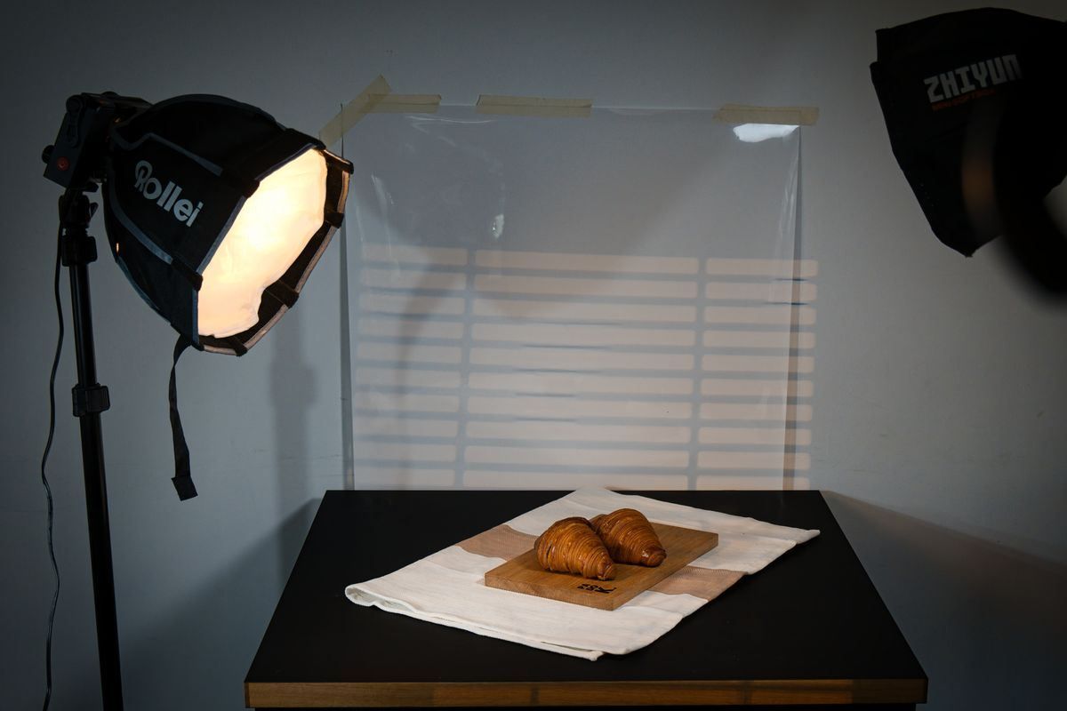 Studio-lit plate with bread on a black table against a white backdrop
