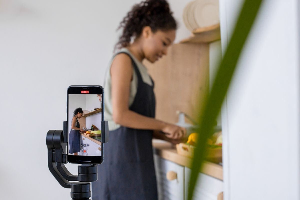 Person cooking in a kitchen, filmed on a smartphone mounted on a tripod.
