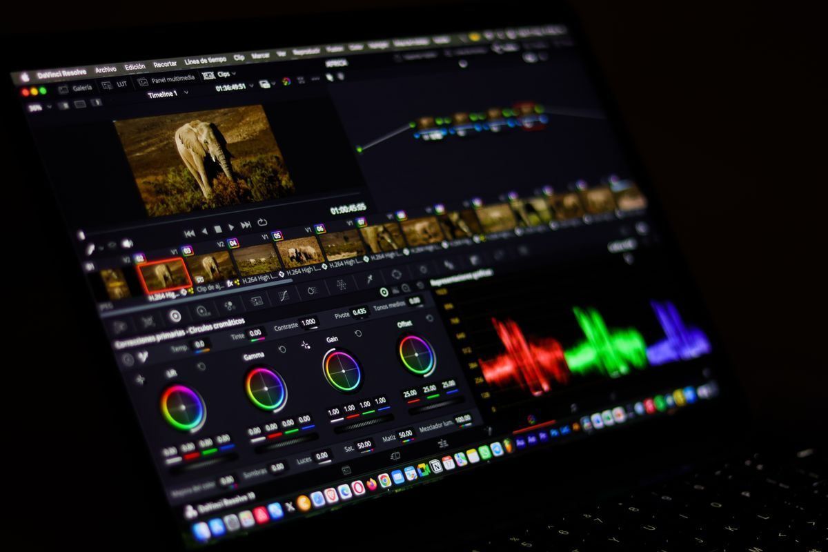 Dark-themed video editing interface with preview, timeline, color wheels, and RGB audio meters