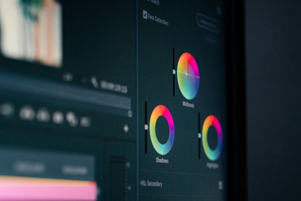 Dark-themed video editing interface with preview, timeline, color wheels, and RGB audio meters