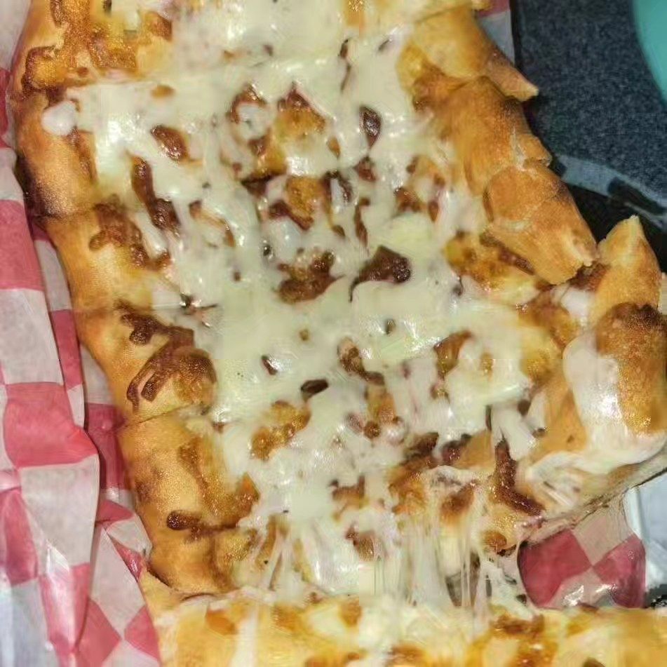 Cheesy baked pasta in a foil tray, with melted mozzarella and browned edges