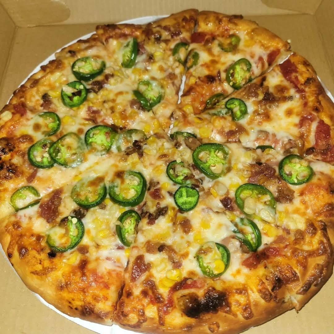 Pepperoni pizza topped with jalapeño slices in a cardboard box