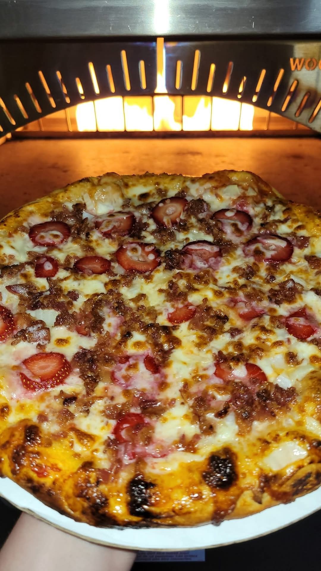 Pepperoni pizza baking in a glowing oven, with bubbling cheese and a browned crust