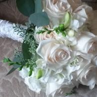 White rose bouquet with green accents and a silver-wrapped handle