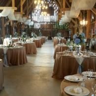 Elegant rustic banquet hall with round tables set for a formal event
