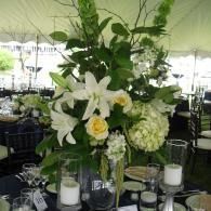 Elegant white floral centerpiece with lilies and hydrangeas on a decorated banquet table