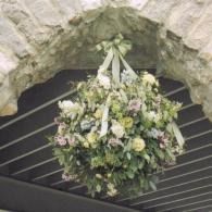 Floral bouquet hanging beneath a stone arch