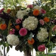 Large floral arrangement with white, pink, orange, and green flowers outdoors