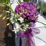 Purple and white flower bouquet with ribbon on a white railing