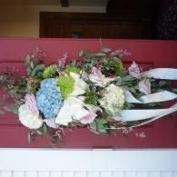 Mixed flower bouquet with pink, white, blue, and green blooms on a red surface